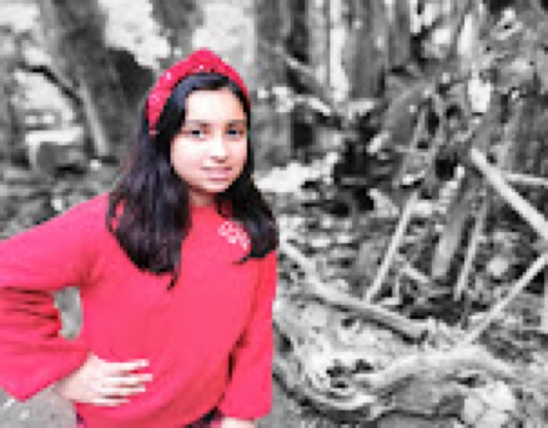9-year-old entrepreneur Sheree holding a handmade sustainable wooden hair comb